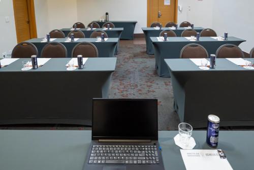 a conference room with a laptop on a table at Intercity Vinhedo in Vinhedo