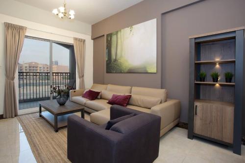 a living room with a couch and a table at BLVD - Spacious Fully Equipped Luxury Residences - Dubai - JVC in Dubai