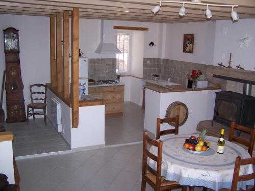 une cuisine avec une table avec un bol de fruits dessus dans l'établissement Gîte au calme, à Nanton