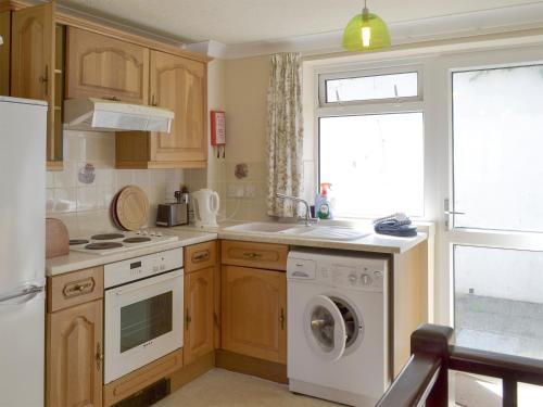 cocina con lavadora y ventana en Westward Ho - Uk44492, en Hope-Cove