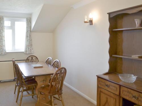 Un comedor con mesa y sillas de madera. en Westward Ho - Uk44492, en Hope-Cove