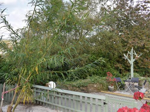a garden with a white fence and a christmas tree at Slant End Cottage in Golcar