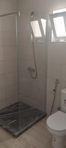 a bathroom with a glass shower with a toilet at Rosesplace Mindelo in Mindelo