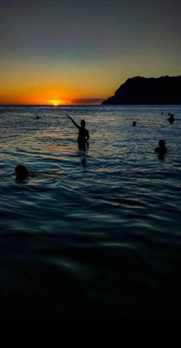 a person standing in the water at sunset at Rosesplace Mindelo in Mindelo