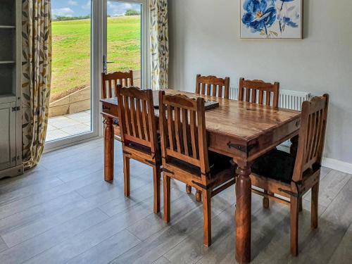 a wooden dining room table with chairs and a window at Fern Lodge - Uk40018 in Halwill