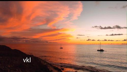 two boats floating in the ocean at sunset at Rosesplace Mindelo in Mindelo