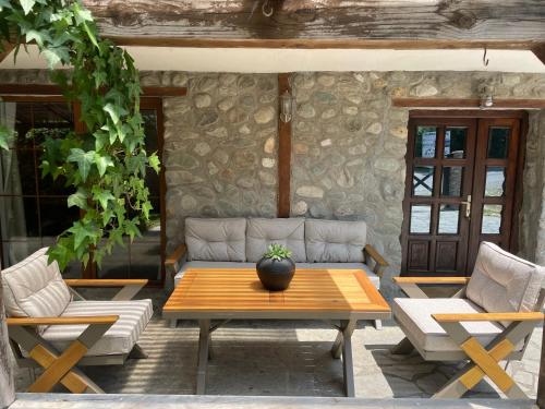 a patio with a couch and two chairs and a table at Snow White Chalet in Brezovicë