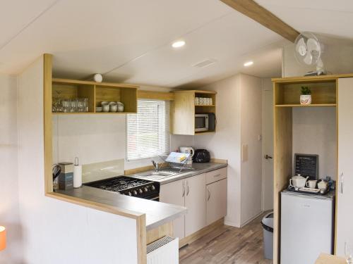 a small kitchen with a stove and a refrigerator at Brimham Retreat - Uk37641 in Knaresborough