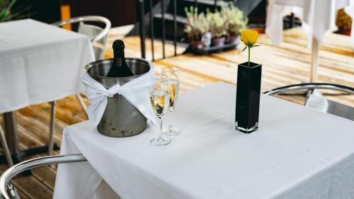 a table with two wine glasses and a vase at Grange Buckingham Hotel in London