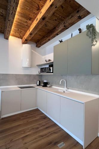 a kitchen with white cabinets and a sink at Appartamento Palazzo in Mestre