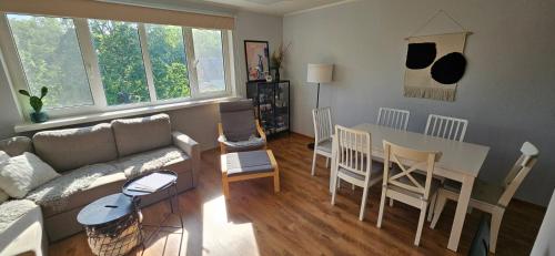 a living room with a couch and a table and chairs at Viscosa Holiday Apartment in Kõrgessaare