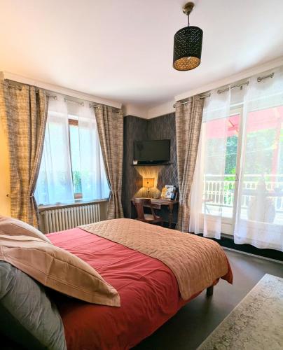 une chambre avec un lit, un bureau et des fenêtres dans l'établissement Chambres d'hotes la forêt, à Longwy