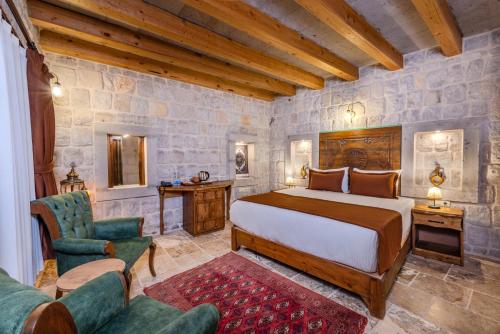 a bedroom with a bed and a couch and chairs at Gala Cave Cappadocia in Goreme