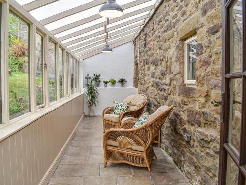 an outdoor patio with wicker chairs and windows at Little Sitch Barn - Uk39602 in Matlock Bank