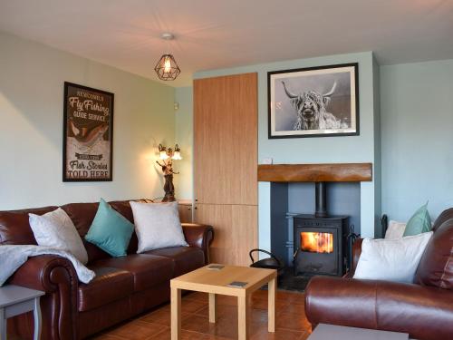 a living room with a couch and a fireplace at Old Stables Cottage in Hunwick