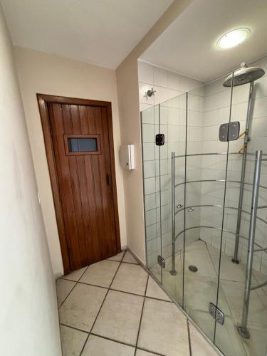 a bathroom with a shower and a glass door at Hotel Estanpla Moema Ibirapuera com garagem piscina 1004 in Sao Paulo