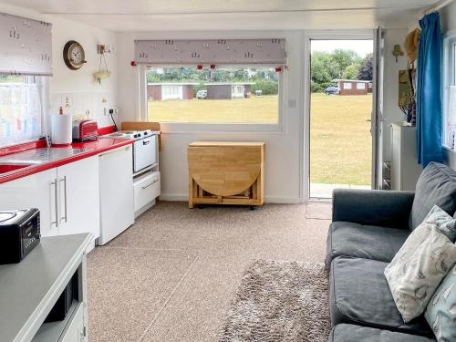 a kitchen and living room with a couch and a table at Driftwood in Mundesley