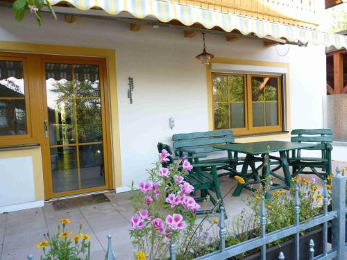 a table and chairs on a patio with flowers at Ferienwohnung Hutterer in Bad Griesbach