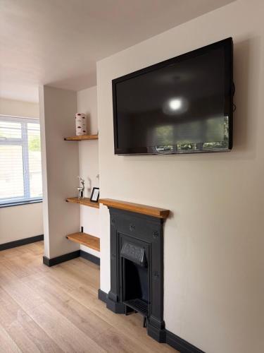 a living room with a fireplace with a flat screen tv on the wall at Cosy One-Bedroom Retreat with Parking in Woodstock