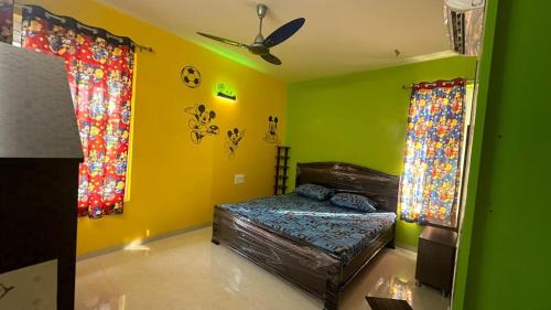 1 dormitorio con paredes de color verde y amarillo y 1 cama en Spgrandrjy, en Godāvari