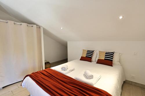 Un dormitorio con una cama blanca con dos almohadas. en Casa di Lilla - Escapade dans une maison de charme, en San-Gavino-di-Carbini