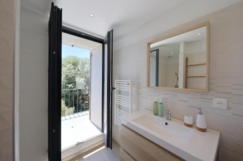 Un baño con lavabo y una gran ventana. en Casa di Lilla - Escapade dans une maison de charme, en San-Gavino-di-Carbini