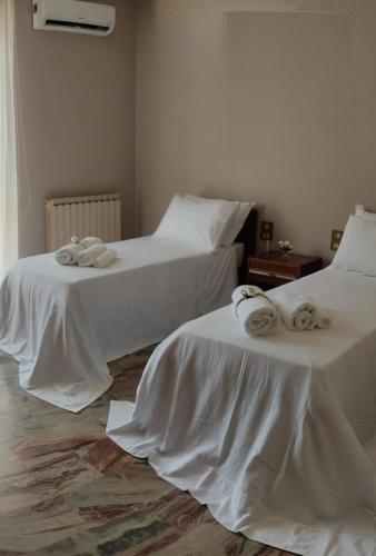 two beds with towels on them in a room at Terry's House in Fondi
