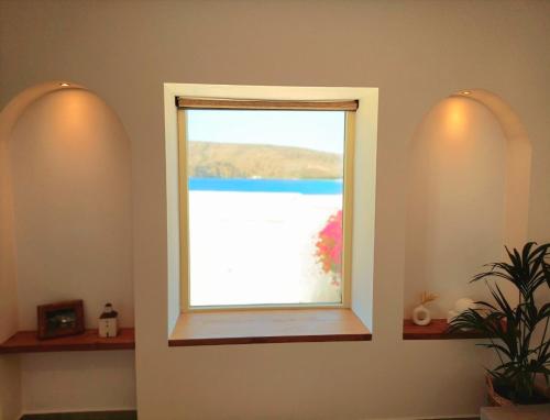 a window in a room with a view of a beach at Vive Mare Milos in Pachaina