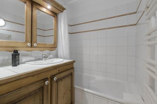 une salle de bain avec un lavabo, un miroir et une baignoire dans l'établissement Appartement Bellevue Au pied des pistes, aux Houches