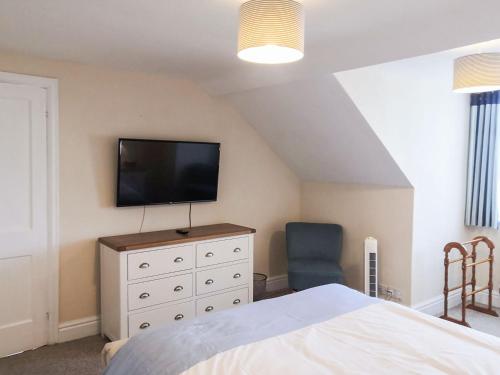a bedroom with a bed and a television on a dresser at Outlook in Stratton