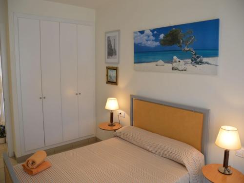 Un dormitorio con una cama y dos lámparas sobre mesas. en Estartit Park 1-1, en Torroella de Montgrí