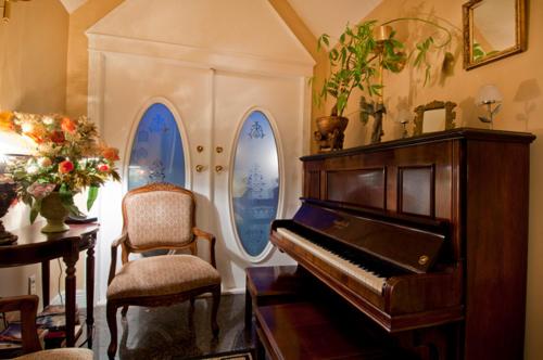 a living room with a piano and a chair at Ocean Breeze Executive Bed and Breakfast in North Vancouver