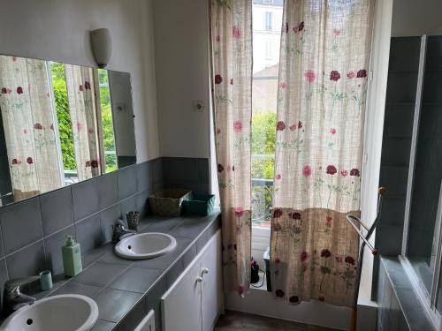 a bathroom with two sinks and a window at Country house in Paris in Boulogne-Billancourt