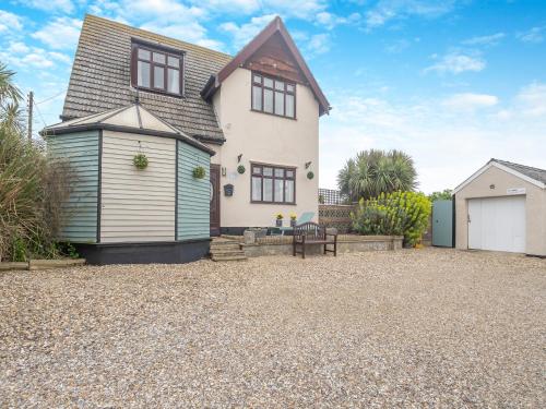 a house with a gravel driveway in front of it at Beachside House in Scratby