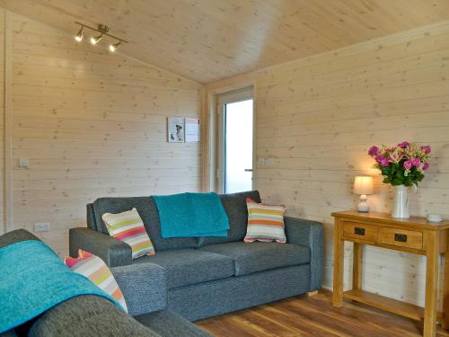 a living room with a couch and a table with flowers at Bransty in Keswick