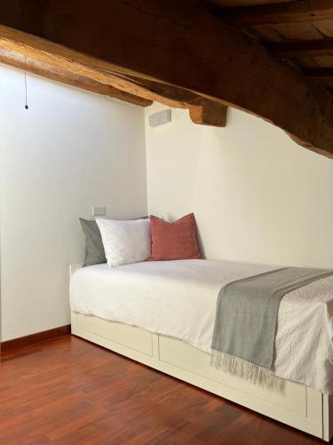 a bed in a room with white walls and wooden floors at Domus Cerchio 19 - Affitti Brevi Italia in Ravenna