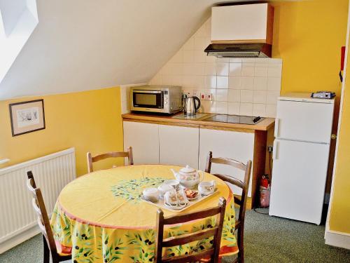 a small kitchen with a table and a microwave at Westonbirt Cottage in Shipton Moyne