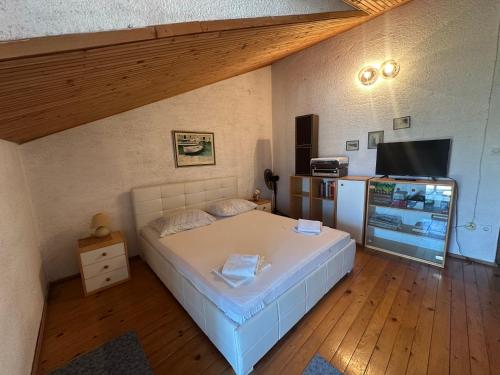 a small bedroom with a bed and a refrigerator at Apartments Renato in Vrboska
