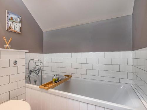 a bath tub in a bathroom with white tiles at The Granary - Uk34899 in Dunira