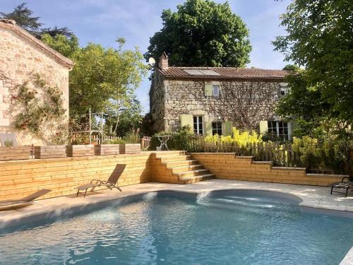 - une piscine en face d'une maison en pierre dans l'établissement Le Clos de Lusignan, à Lusignan-Petit