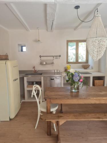 une cuisine avec une table en bois et un vase de fleurs. dans l'établissement Gîte Villa gloria 2, à Landaul