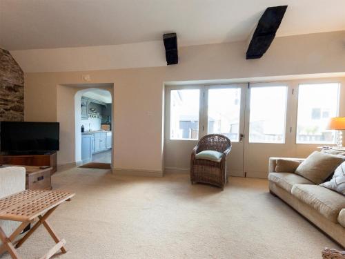 Una sala de estar con un sofá y un televisor. en Aloft, en Salcombe