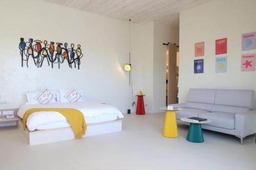 a white bedroom with a bed and a couch at Escape by Orchid in Batroûn