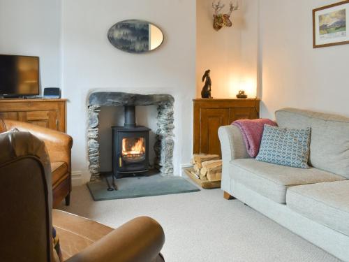 a living room with a fireplace and a couch at Campbell Cottage in Windermere