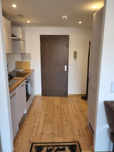 a kitchen with a brown door and a wooden floor at Ferienwohnung Zum Hochgrat in Oberstaufen