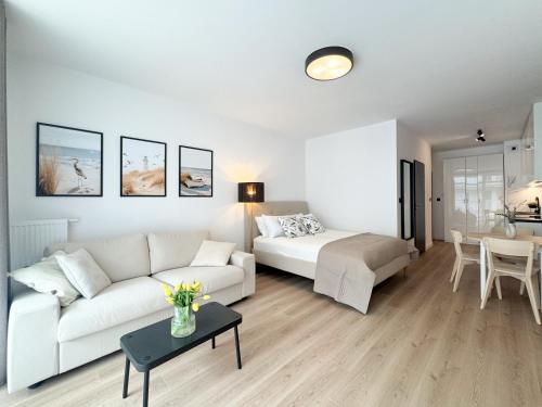 a living room with a white couch and a table at Apartamenty Florina Q4Apartments in Łeba