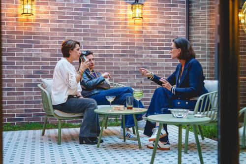 a group of three people sitting around a table at The Originals Boutique, Hôtel Le Londres, Saumur in Saumur