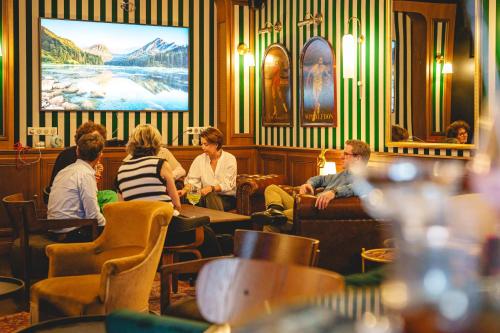 a group of people sitting in a restaurant at The Originals Boutique, Hôtel Le Londres, Saumur in Saumur