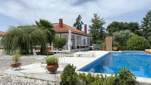 a house with a swimming pool in front of a house at Casa do Jardim in Palmela