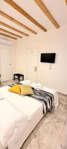 a large white bed in a room with a tv at Vida Casa Vacanze in Murta Maria